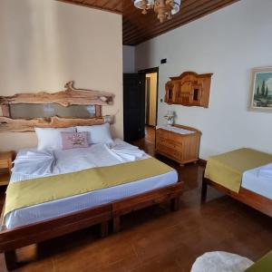 ein Schlafzimmer mit einem großen Bett und einem Kopfteil aus Holz in der Unterkunft Olivia1845 Guest House Ayvalık in Ayvalık