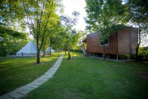 a small wooden house and a tent in a park at Lake Shkodra Resort in Grilë
