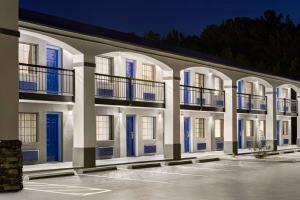 a white building with blue doors and windows at Days Inn by Wyndham Fulton in Fulton