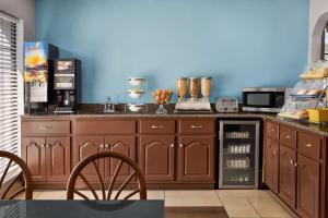 a kitchen with brown cabinets and a blue wall at Days Inn by Wyndham Fulton in Fulton