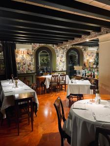 a restaurant with tables and chairs with white table cloth at Locanda Lo Scudo in Soave +17 photos