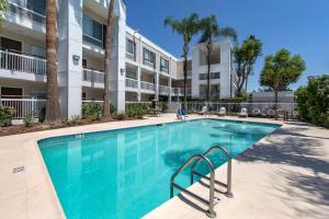 a swimming pool in front of a apartment building at Quality Inn Placentia Anaheim Fullerton in Placentia