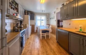 een keuken met houten vloeren en een tafel. bij Amazing Home In Vanvik With Kitchen in Sand