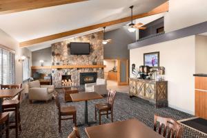 a lobby with a fireplace and tables and chairs at AmericInn by Wyndham Bemidji in Bemidji