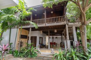 a villa with a large wooden house with a balcony at Casa Amor in Phumi Ta Phul