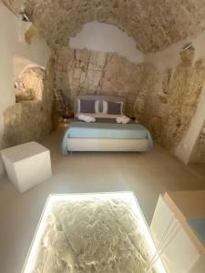 ein Schlafzimmer mit einem Bett in einem Steinzimmer in der Unterkunft Cà sotto l’arco in Ostuni