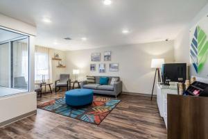 WoodSpring Suites Harrisburg Linglestown في هاريسبورغ: غرفة معيشة مع أريكة وتلفزيون