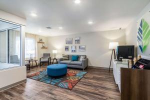 a living room with a couch and a tv at WoodSpring Suites Harrisburg Linglestown in Harrisburg