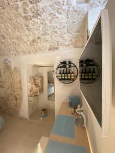 Zimmer mit einer Theke mit einem Waschbecken und einer Steinmauer in der Unterkunft Cà sotto l’arco in Ostuni