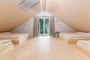 an attic room with beds and a window at NaturparkResort Lausernest in Wildalpen