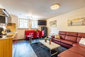 ein Wohnzimmer und eine Küche mit einem Sofa und einem Tisch in der Unterkunft Villa Scandic Apartments in Rust