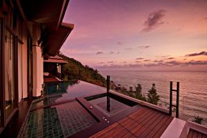 a house with a swimming pool overlooking the ocean at Banyan Tree Samui in Lamai