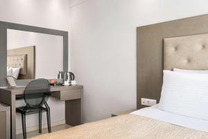 A bed or beds in a room at TRYP by Wyndham Corfu Dassia