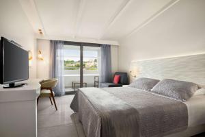 A bed or beds in a room at TRYP by Wyndham Corfu Dassia