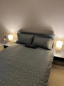 a bedroom with a large bed with two lamps at Ultra Modern Room in London