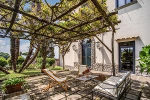 eine Terrasse mit Stühlen und einem Tisch im Hof in der Unterkunft Villa Aragona in Massa Lubrense