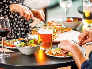 una mesa con platos de comida y un vaso de cerveza en ibis Nova Serrana, en Nova Serrana
