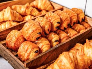 un montón de croissants en bandejas en una panadería en ibis Nova Serrana, en Nova Serrana