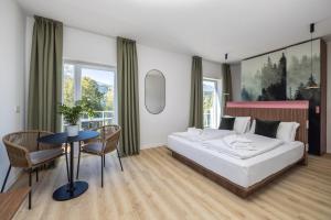 Hotel Al Sorriso Greenpark & Wellness في ليفيكو تيرمي: غرفة نوم بسرير وطاولة وكراسي
