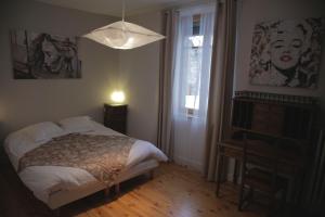 1 dormitorio con cama, ventana y lámpara en Le Square, en Bourg-Argental