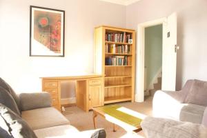 Suite 1 - Cosy Room Close to MCR City Centre في مانشستر: غرفة معيشة مع أريكة ورف كتاب