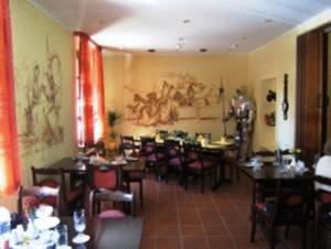 a restaurant with tables and chairs and a painting on the wall at Hotel Restaurant Zum Alten Ritter in Bad Bodenteich