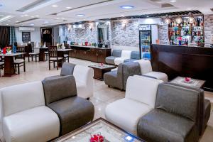a bar with white chairs and tables in a restaurant at Séréna Hôtel in Douala