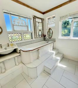 a white bathroom with a sink and a mirror at Tree Tops Holiday Let & Sauna South Downs West Sussex Sleeps 10 in Hardham