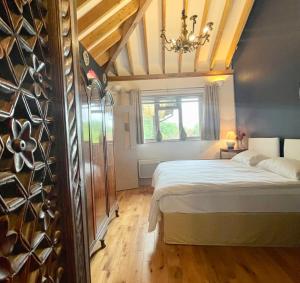 Tree Tops Holiday Let & Sauna South Downs West Sussex Sleeps 10 في Hardham: غرفة نوم مع سرير وقبو للنبيذ