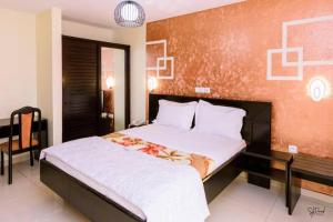 a bedroom with a large bed and a chair at Séréna Hôtel in Douala +33 photos