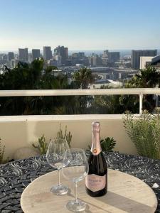 a bottle of wine and two wine glasses on a table at The View Cape Town in Cape Town