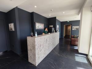 诺拉Hotel XBusiness的站在大厅柜台的女人