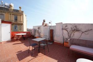 um pátio com uma mesa e cadeiras no telhado em numa I Seda Apartments em Barcelona