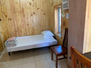 um pequeno quarto com uma cama e uma parede de madeira em Happytourcairns sharehouse em Cairns
