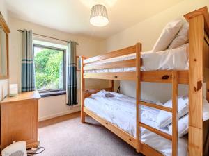 グレンジ・オーバー・サンズにあるBarn Owl Cottageのベッドルーム1室(二段ベッド2台、窓付)が備わります。