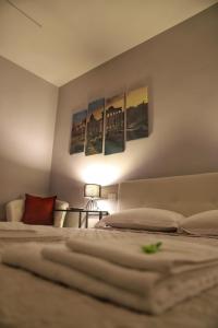 1 dormitorio con 2 camas y pinturas en la pared en Cavour Home, en Roma