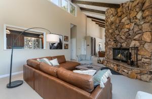 a living room with a couch and a stone fireplace at Cedar Upper Condominium 3 Bedroom condo in Estes Park