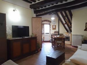 un salon avec une télévision et une salle à manger dans l'établissement Borgo medievale Arcidosso, à Arcidosso