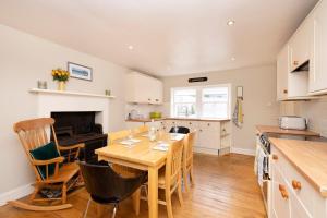 cocina y comedor con mesa de madera y sillas en 2 bed Haywood Cottage with garden, en Stenton