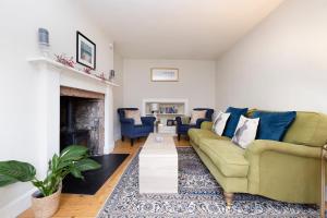 sala de estar con sofá y chimenea en 2 bed Haywood Cottage with garden, en Stenton
