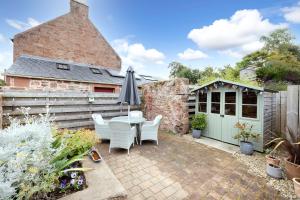 a patio with an umbrella and a table and chairs at 2 bed Haywood Cottage with garden in Stenton