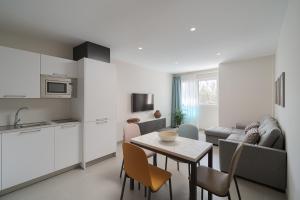 a kitchen and a living room with a table and chairs at Las Afortunadas - Playa Arinaga 2ºA in Arinaga