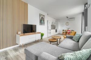 a living room with a couch and a tv at Aparthotel 1899 in Szczecin