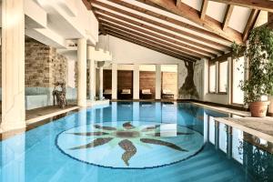 a swimming pool with a mosaic floor in a building at Hotel Salvadori in Mezzana
