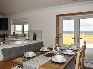 a kitchen and dining room with a table with a view of the ocean at Ryka Lodge in Back