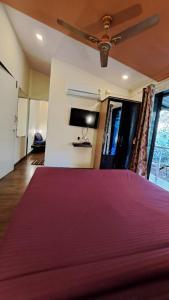 a bedroom with a bed and a ceiling fan at Neuaura Stays in Mahabaleshwar