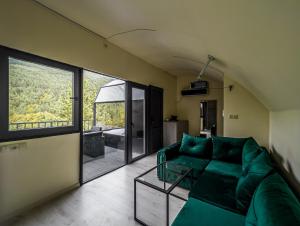 安布羅勞里的住宿－Glamping Georgia Krikhi，客厅配有绿色沙发和玻璃桌