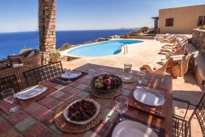 a table with a bowl of fruit on top of a patio at Als Marmarei in Ioulis