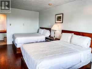 una camera d'albergo con due letti e una lampada di Tantramar Motel a Sackville