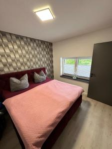a bedroom with a large bed with a pink blanket at Ferienwohnung Hardo in Alt Schwerin